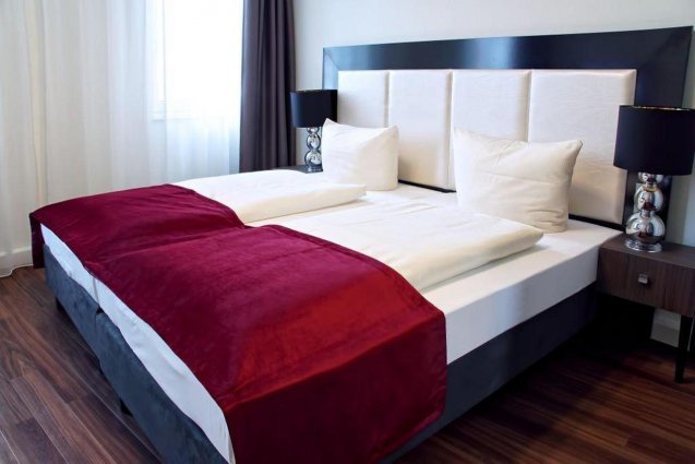 Tweepersoonskamer met rood dekbed Baron am Schottentorn in Wenen