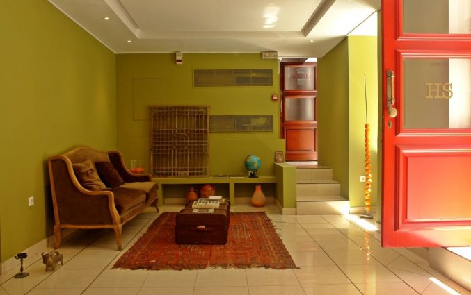 Lobby met bank, tafel en rode deur van hotel Semeli stedentrip Athene